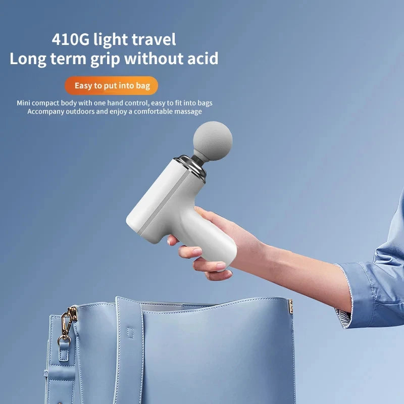 Person holding portable AI massage gun above a light blue handbag on a blue background