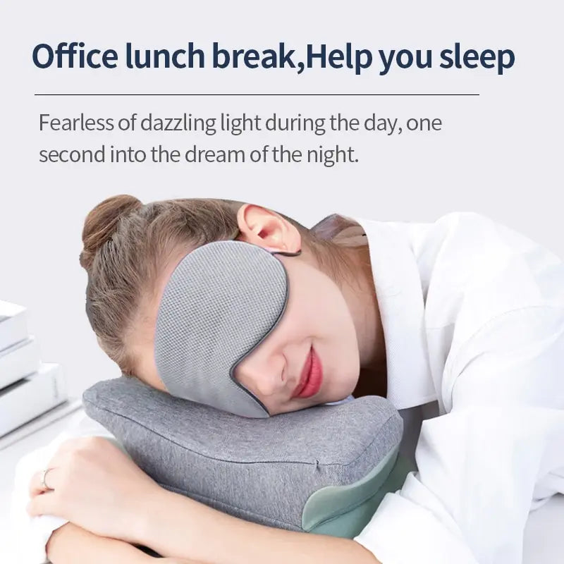 Woman wearing gray hot and cold sleep mask resting head on gray pillow during office lunch break