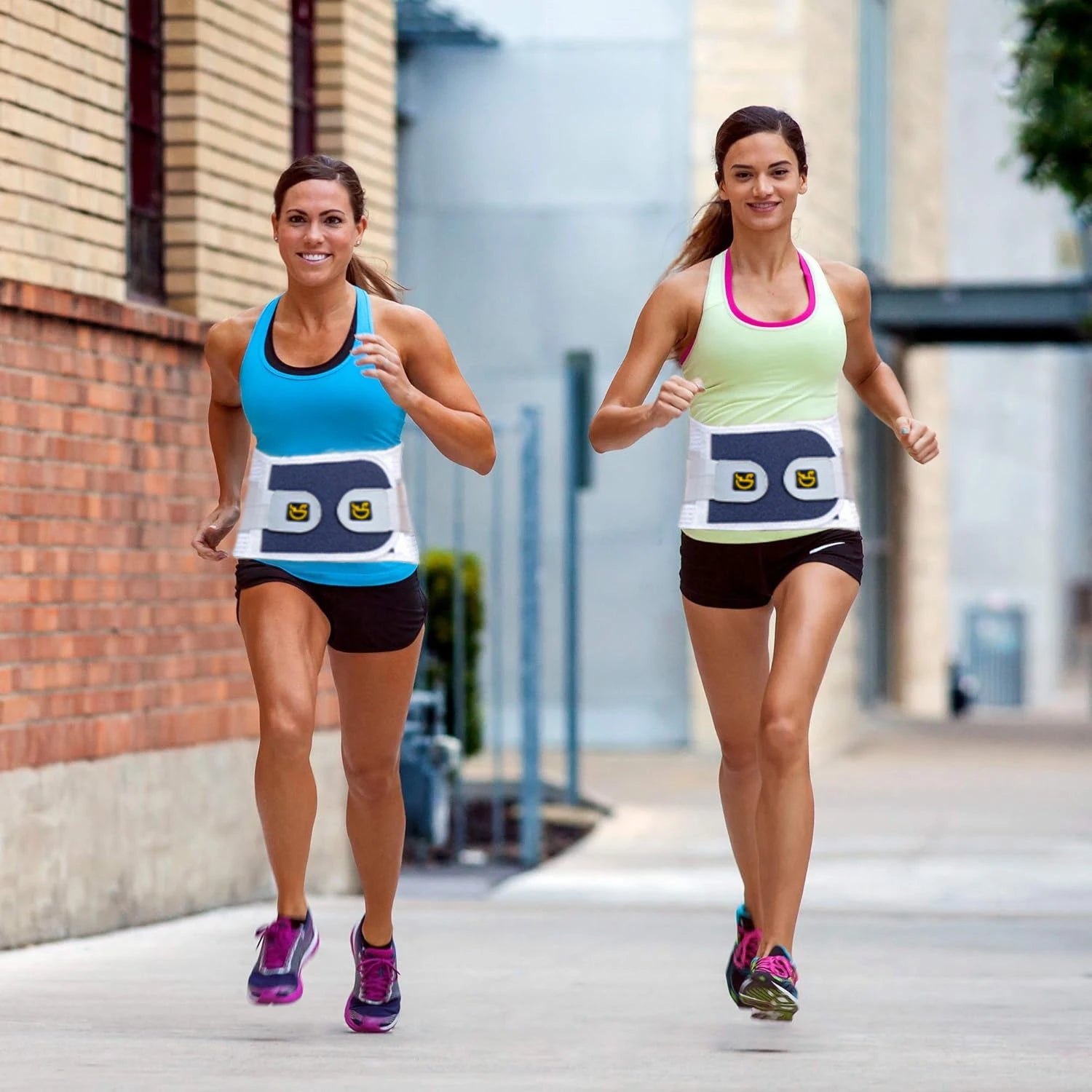 Two women running outdoors wearing adjustable back brace support belt for posture and pain relief