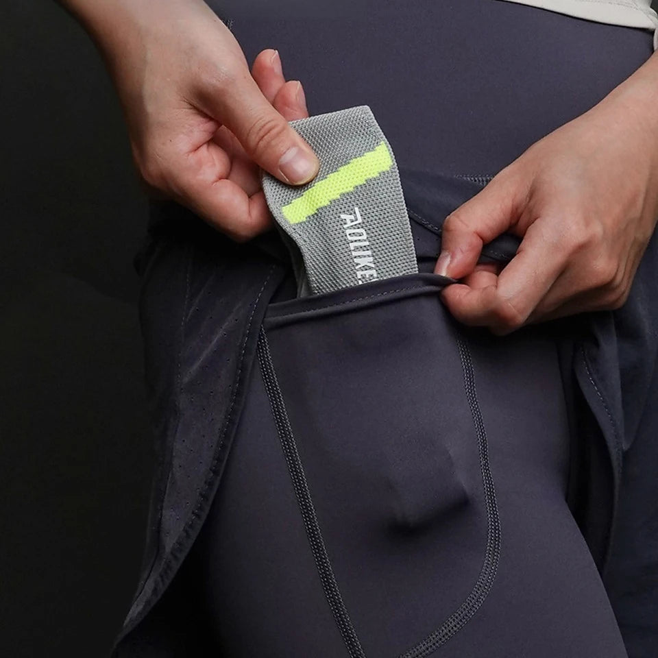 Person placing patella knee strap for pain relief into pocket of black athletic leggings