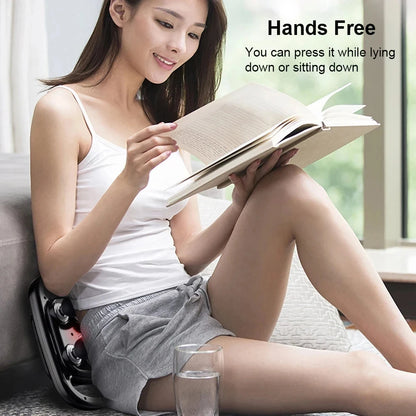 Woman using Zorelie deep tissue massage gun for pain relief hands free while reading a book at home