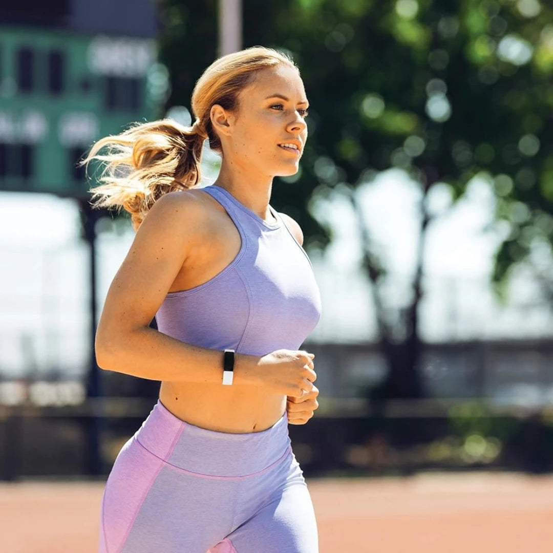 Woman jogging outdoors wearing a waterproof heart rate smart band on her wrist