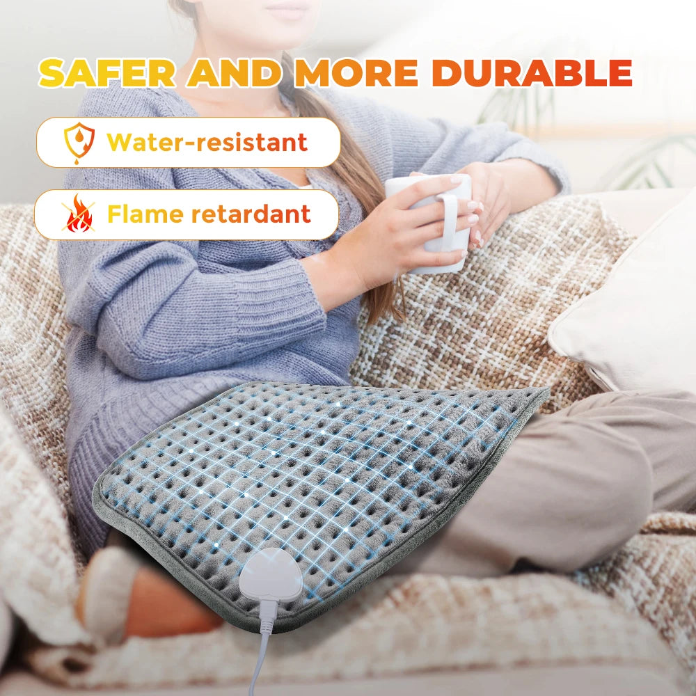 Woman using electric heating pad for pain relief on her leg while sitting on a couch holding a mug