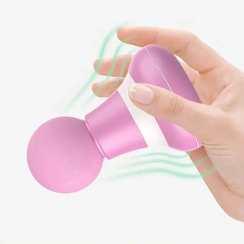Handheld mini muscle massage gun in pink held in hand for targeted muscle relief