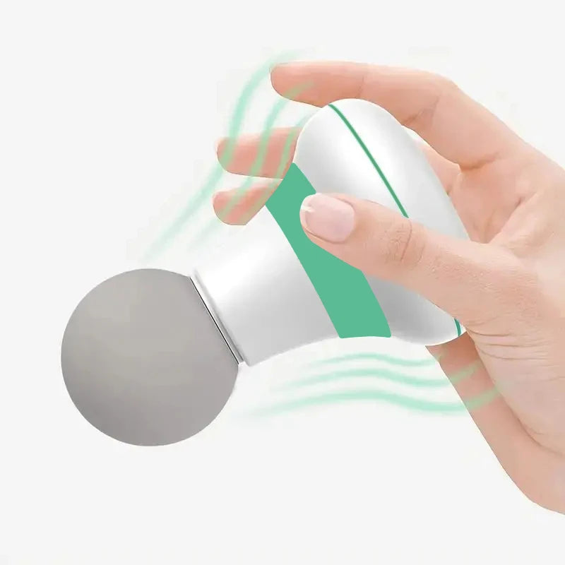 Hand holding a handheld mini muscle massage gun with a round grey massage head and white green body