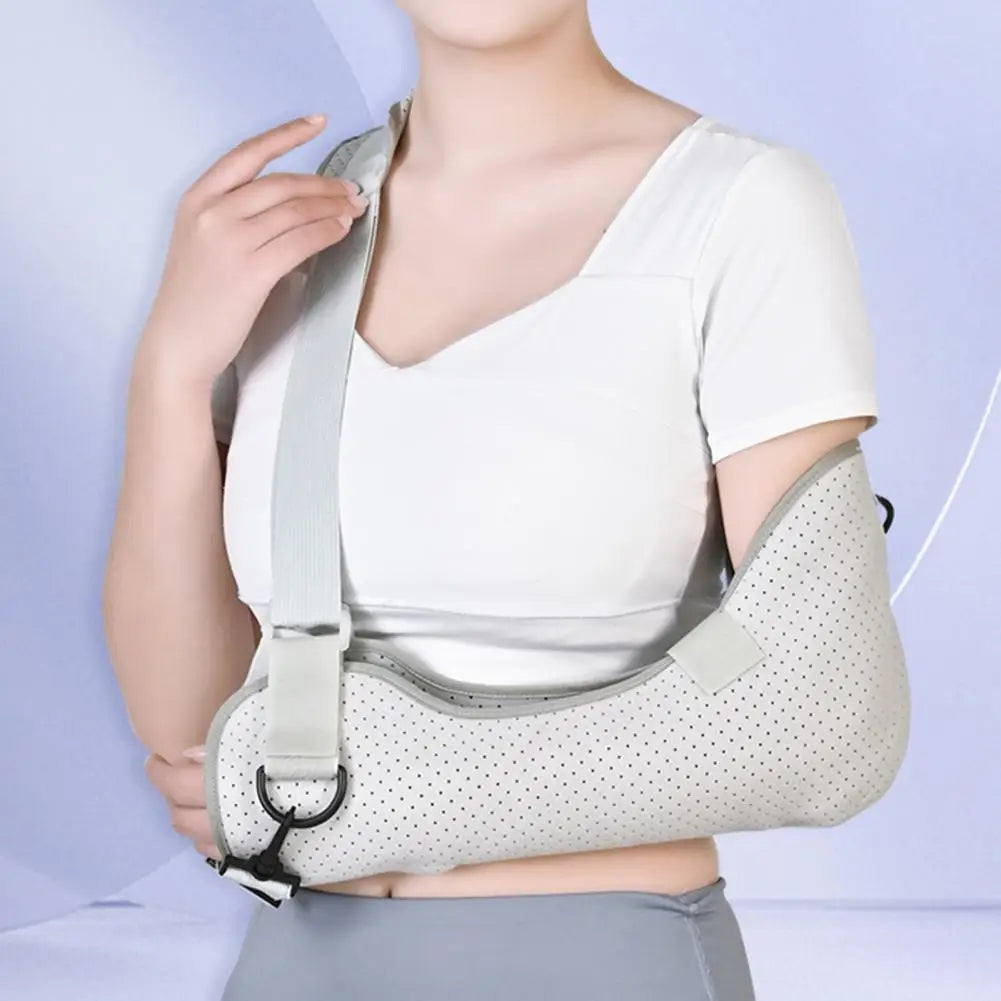 Adjustable kids arm sling adjustable in light gray with breathable holes worn by a child