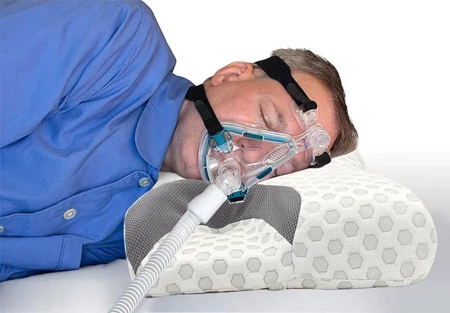 Man wearing CPAP mask resting on a memory foam sleep apnea pillow with breathable cover