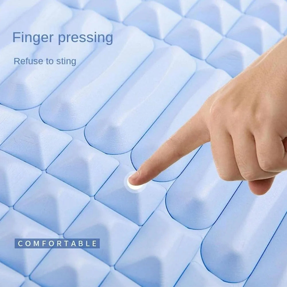 Finger pressing the soft blue orthopedic back stretcher pillow showing its comfortable texture