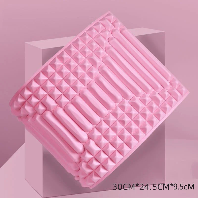 Pink orthopedic back stretcher pillow with textured surface for spinal support and pain relief