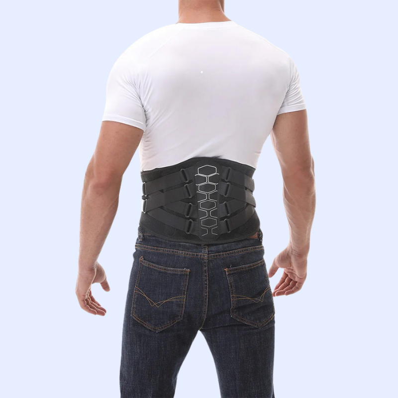 Man wearing a black lumbar back brace for pain relief secured over jeans and white shirt from back view