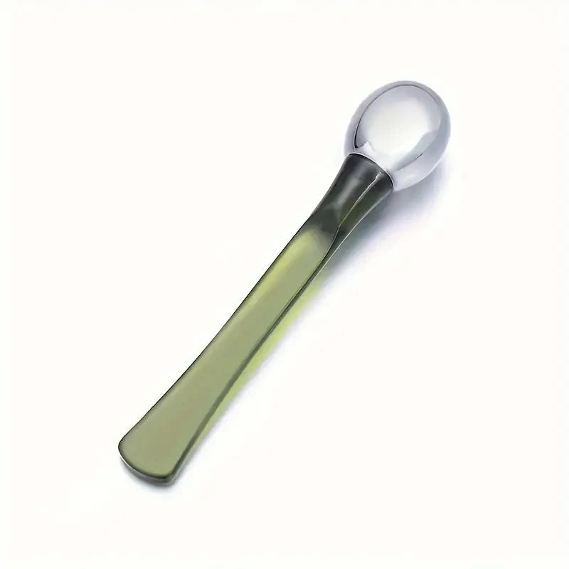 Zorelie.co under eye roller massage stick with green handle and silver rounded roller head