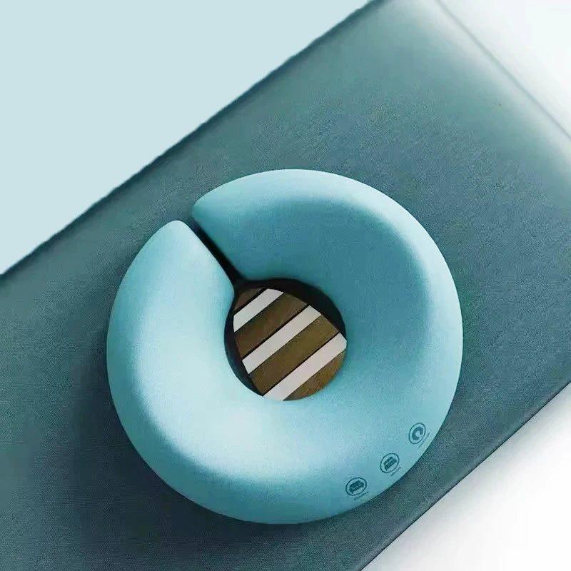 Light blue ergonomic face rest pillow for massage placed on dark surface for comfort support