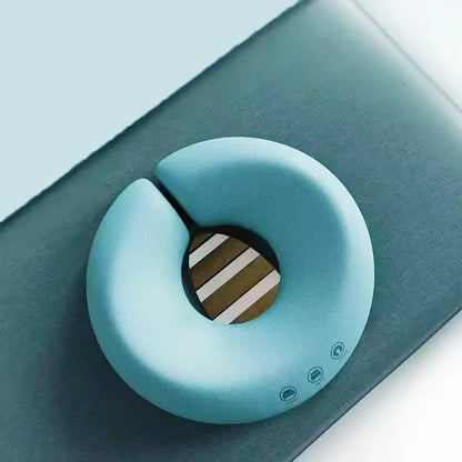 Light blue ergonomic face rest pillow for massage placed on dark surface for comfort support
