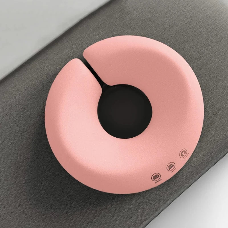 Pink ergonomic face rest pillow for massage placed on a gray surface for comfortable support