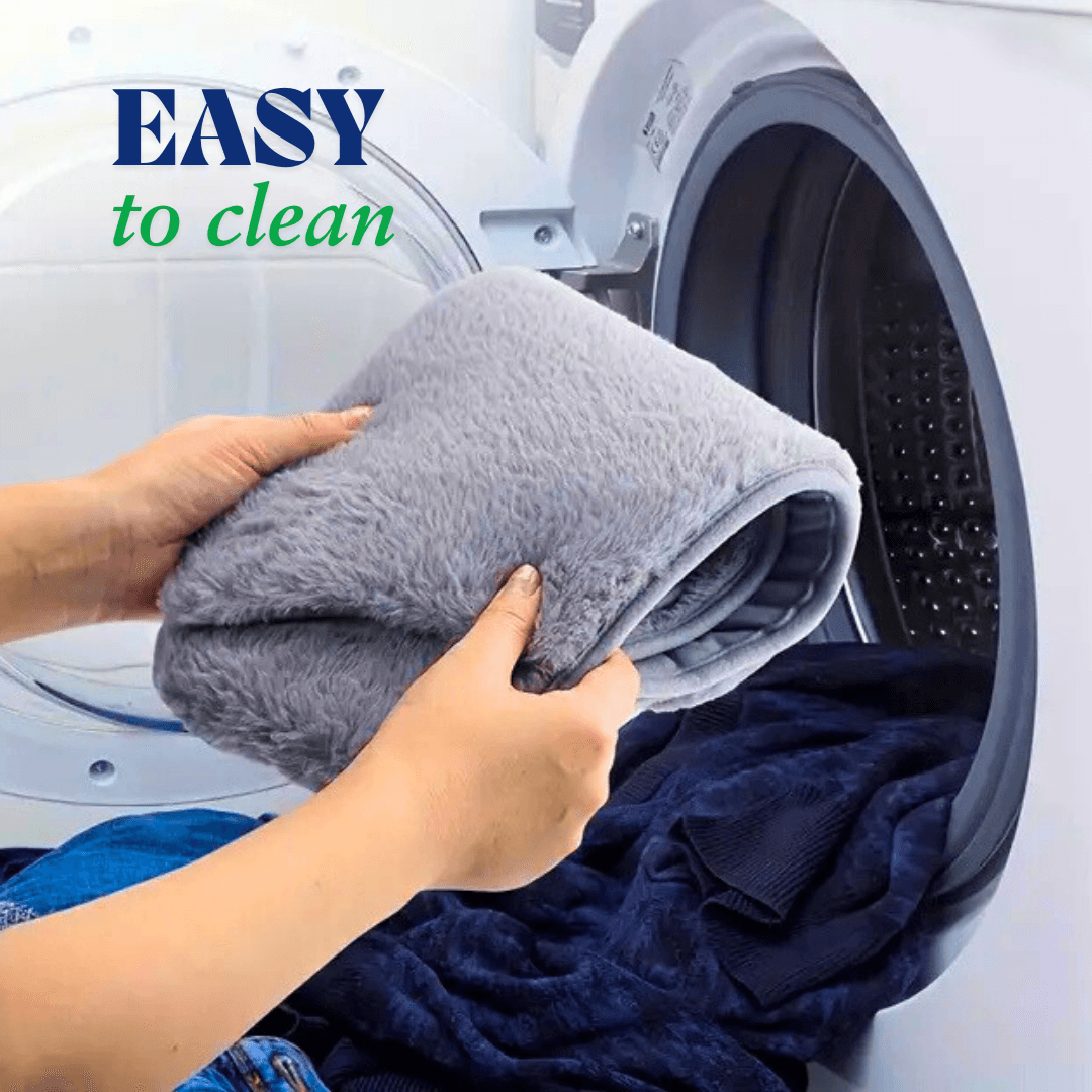 Gray soft menstrual heating pad for cramps being placed into a washing machine showing easy to clean feature